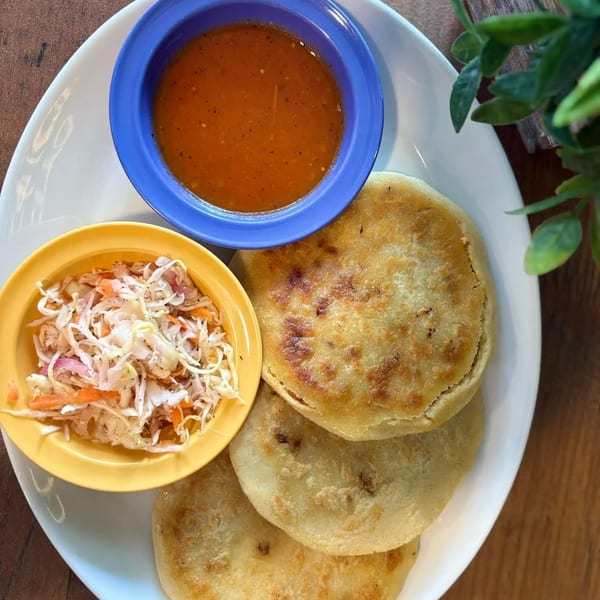 Moyitos Cafe & Grill's pupusas with curtido and salsa on a white plate.
