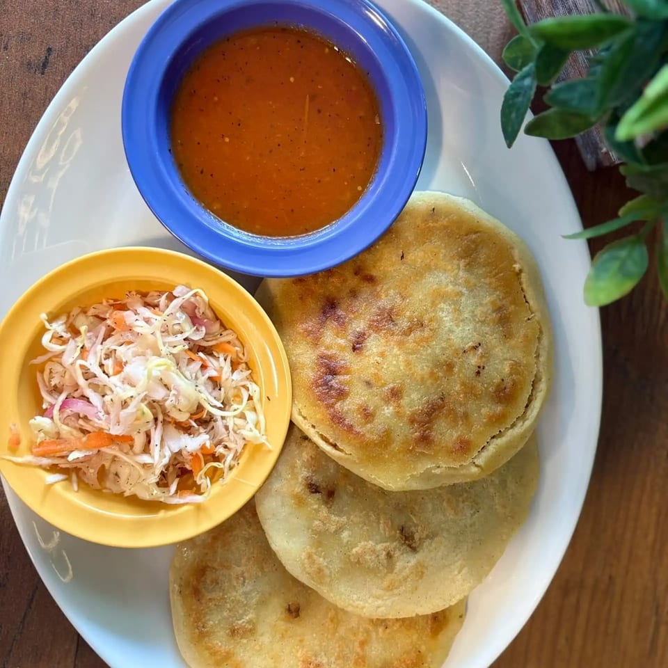Moyitos Cafe & Grill's pupusas with curtido and salsa on a white plate.